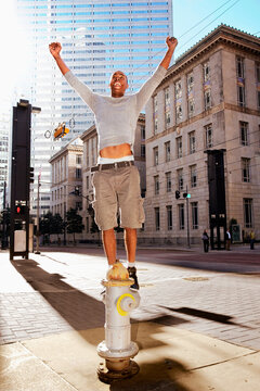 Man standing on fire hydrant on street corner