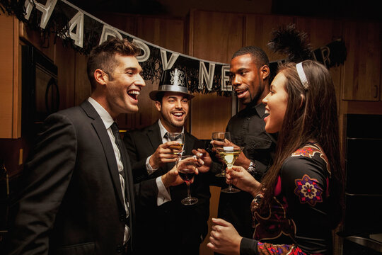 Friends drinking in kitchen at New Year's Eve party
