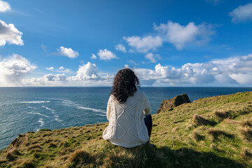 The woman sits and enjoys ocean view from the Silver Strand in Malin Beg, near Glencolmcille, South...