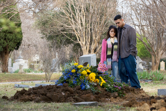 Young Hispanic couple at grave