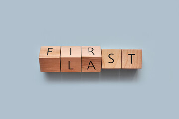 Wooden cubes with the inscription: first and last. Victories and defeats in human life