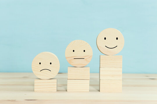 Concept image of satisfaction level. wooden circles with emotions