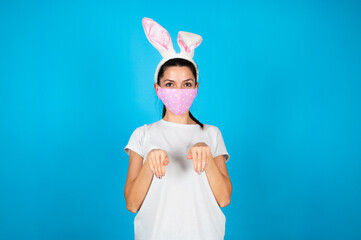 Funny portrait of woman wearing Bunny ears and heart print protective mask. Holidays concept. Happy Valentine's day. Happy easter.