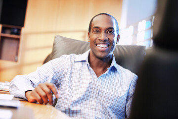Smiling African American businessman sitting at desk