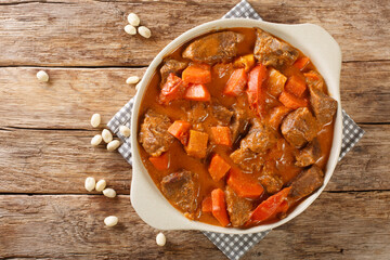 Senegalese stew of beef in peanut sauce with vegetables close-up in a dish on the table. horizontal top view from above
