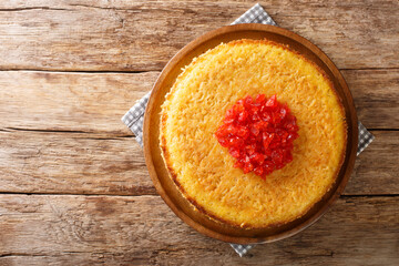 Iranian Tahchin Rice Cake With chicken closeup in the plate on the table. Horizontal top view from above