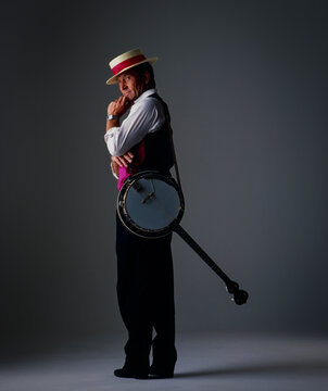 Male Jazz musician standing and looking back with his Banjo over his shoulder