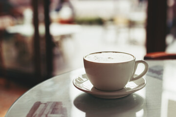 Cup of morning cappuccino on a table in a old cafe.