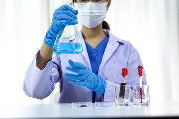 Fototapeta premium Scientist holding Coronavirus covid-19 infected blood sample tube DNA testing of the blood in the laboratory with blood sample collection tubes and syringe Coronavirus Covid-19 vaccine research.