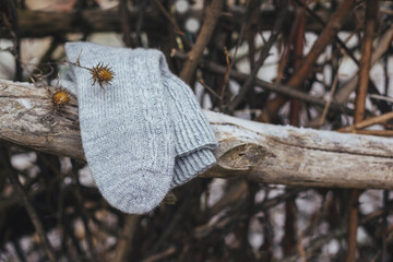A pair of grey hand knitted socks on a dark rustic background.
