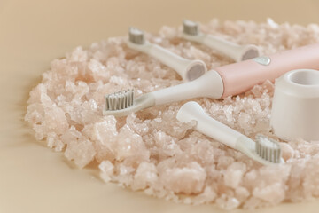 Fototapeta na wymiar Ultrasonic toothbrush with replaceable heads and charging on sea salt crystals