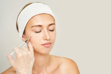 Cheek injection at spa salon. Doctor hands. Pretty female patient. Beauty treatment. Healthy skin...