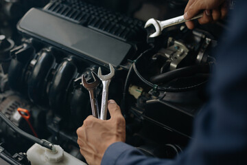 Fototapeta na wymiar Car service, repair, maintenance concept. Auto mechanic working in garage.