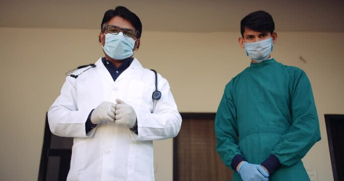 Low angle two short of doctor with nurse give instructs request plead demand using hand gestures signs to demonstrate  and join hands to request in prayer position of greeting Namaste 