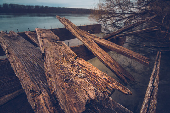 Broken wooden plates by body of water
