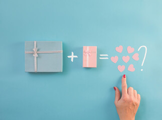 Gifts decorated with ribbon on blue background, woman hand finger points small hearts. Flat lay, blue and pink present boxes, top view. Valentine, spring holidays, Christmas, birthday concept.