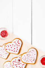 Homemade cookies for valentine's day sprinkled with hearts on a light background with copy space.