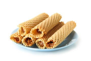 Plate with wafer rolls with condensed milk isolated on white background