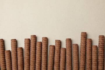 Chocolate wafer rolls on gray background, top view