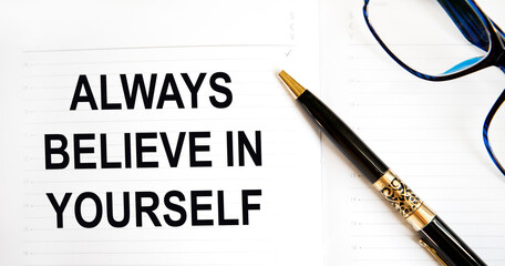 In the diary the text always believe in yourself, next to the pen and glasses.