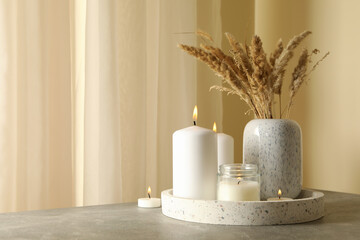 Tray with scented candles and reed on gray table