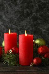 Fototapeta na wymiar Candles, baubles and pine branches on wooden background
