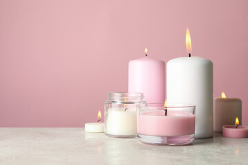 Scented candles for relax on white table against pink background
