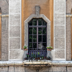 Fototapeta na wymiar Rome Italy, vintage building balcony arched window decorated with colorful flowers