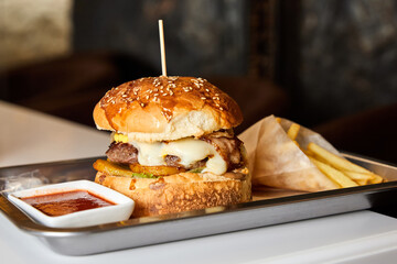 Fast food hamburger and french fries on a metal plate