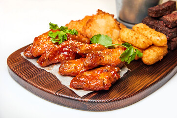 Beer set of cheese sticks, chicken nuggets and wings, French fries, rye toasts on white background. Close-up, selective focus