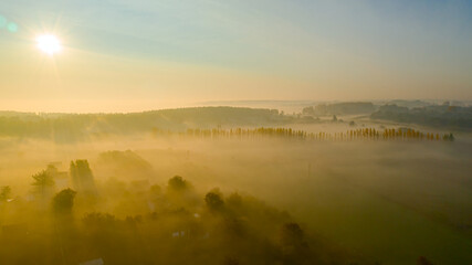 Aerial view of early morning mist over houses, weekend resort in woodland