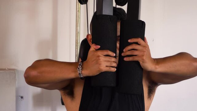 close up of a man exercising on a chest machine fly