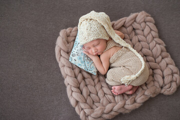 Newborn baby in a cap on a brown background