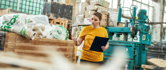 Young woman checking information about boxes with rubbish