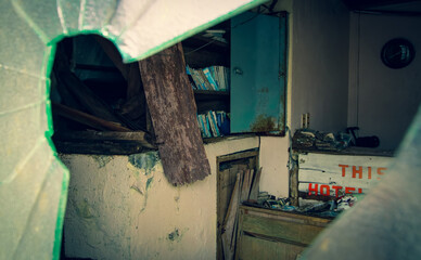 Photo of the interior of an abandoned hotel in Japan taken through a broken window
