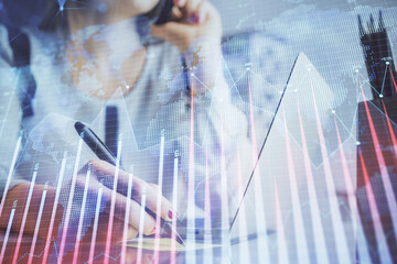 Double exposure of woman hands typing on computer and financial graph hologram drawing. Stock market analysis concept.