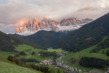 Small Italian mountain town of St. Magdalena in Val di Funes at sunset