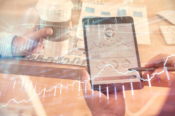 Double exposure of man's hands holding and using a phone and financial chart drawing. Market analysis concept.