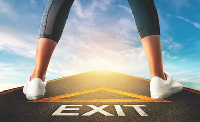 Fototapeta na wymiar Woman standing on exit signage road for Business exit strategy concept with blue sky background.