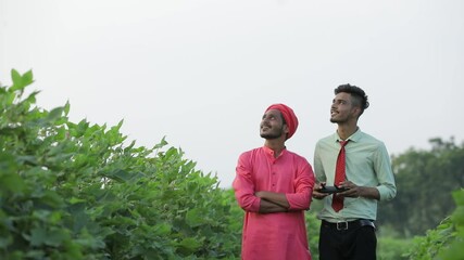 Indian farmer and agronomist using drone at agriculture field