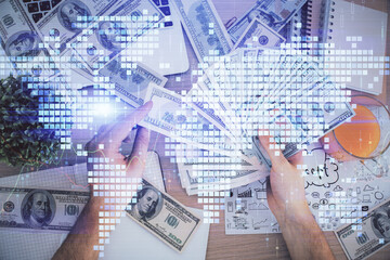 Multi exposure of financial theme drawing hologram and USA dollars bills and man hands. Business concept.