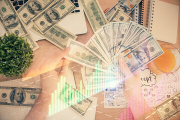 Obraz premium Multi exposure of financial graph drawing hologram and USA dollars bills and man hands. Analysis concept.