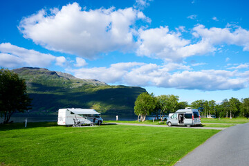 Sehr schöner Campingplatz mit Wohnmobil mit Berg und See im HIntergrund - obrazy, fototapety, plakaty