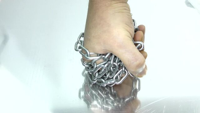 Hand with chain on a white background.  Concept of Fight and Freedom. Preparing for a violent fight.