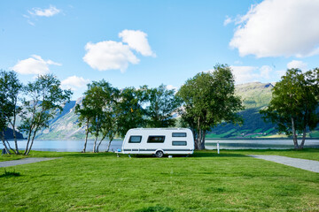 Toller Camping platz mit Wohnwagen im Hintergrund Berge und See als Banner für Homepage - obrazy, fototapety, plakaty