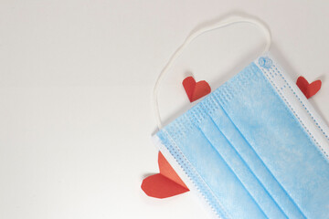 red heart on a mask on valentine's day on a white isolated background. heart surgical mask with place for inscription, mock up, copy space
