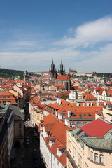 Fototapeta na wymiar Tynsky and St Vitus cathedral among the red roofs of Prague. View from above