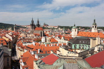 Fototapeta na wymiar Tynsky and St Vitus cathedral among the red roofs of Prague. View from above