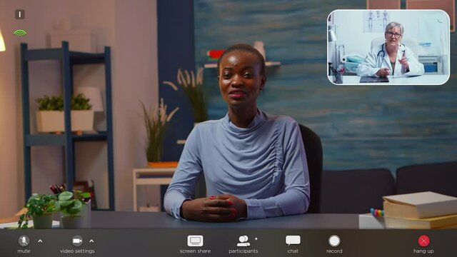 African famele having conference call with doctor about illness treatment sitting home late night. Patient in a video call with medic discussing health problems, footage with software overlay concept