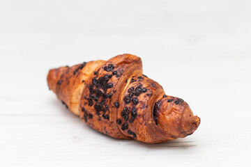 From above of delicious fresh crusty croissant and pieces of dark chocolate composed on a light background.